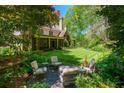 Backyard showing stone patio, outdoor seating, mature shade trees and lush lawn at 2167 W Wesley Nw Rd, Atlanta, GA 30327
