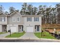 Charming townhome exterior featuring an attached garage, neat lawn and dark-trimmed windows at 4284 Sw Notting Hill Dr # 20, Atlanta, GA 30331