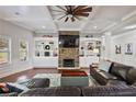 Inviting living room features a stone fireplace, custom built-ins, coffered ceiling and ample natural light at 1622 Bunting Forest Ct, Marietta, GA 30064