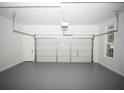 Clean, empty two car garage with white walls and gray floors ready for vehicles and storage at 2328 New Haven Pl, Conyers, GA 30094