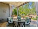 Cozy covered patio with outdoor seating, ceiling fan and serene backyard views at 6382 Mountain Ridge Cir, Sugar Hill, GA 30518