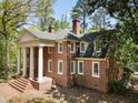 Brick home featuring white columns, dormer windows, and a well-manicured lawn at 1961 River Forest Rd, Atlanta, GA 30327
