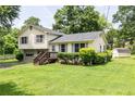 Well-kept home with a lush green lawn and mature trees, complemented by a storage shed in the backyard at 4424 Robinson St, Acworth, GA 30101