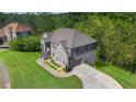 An aerial view of the two-story gray brick home with attached garage and manicured grounds at 3206 Letha Woods Dr, Conyers, GA 30094