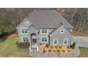 Beautiful grey brick home with a well-manicured lawn and mature trees at 3206 Letha Woods Dr, Conyers, GA 30094