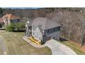 View of a beautiful grey brick home, with a long driveway and manicured landscaping at 3206 Letha Woods Dr, Conyers, GA 30094