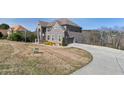 A gray brick two-story home with an attached two-car garage and a long, paved driveway at 3206 Letha Woods Dr, Conyers, GA 30094