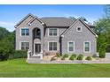 Imposing two-story gray brick home with well-manicured lawn, mature trees, and beautiful landscaping at 3206 Letha Woods Dr, Conyers, GA 30094