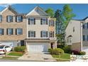 Charming multi-story townhouse featuring a two-car garage, well-manicured lawn, and mature landscaping at 420 Eagle Tiff Dr, Sugar Hill, GA 30518