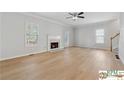 Bright living room featuring hardwood floors, fireplace, a ceiling fan and lots of natural light at 420 Eagle Tiff Dr, Sugar Hill, GA 30518