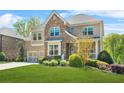 Beautiful two-story home featuring a brick and stone exterior, a well-maintained lawn, and a two-car garage at 5895 Springbox Dr, Suwanee, GA 30024