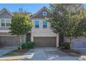 Lovely exterior view of townhome featuring a two-car garage, brick facade and small, manicured trees at 2721 Kemp Sw Ct, Conyers, GA 30094