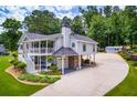 Expansive exterior featuring a wrap-around porch, a multi-car garage, and lush landscaping at 84 Ledbetter Rd, Villa Rica, GA 30180