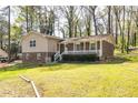 View of a two-story brick home with charming front porch amid mature trees and a grassy lawn at 2755 Austin Ln, Jonesboro, GA 30236