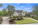 Charming two-story home boasting lush greenery, manicured bushes and a curved driveway at 9315 Prestwick Club Dr, Johns Creek, GA 30097
