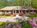 Well-maintained brick home featuring a symmetrical facade and beautiful landscaping at 6141 Windsong Way, Smoke Rise, GA 30087