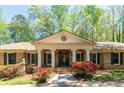 Lovely brick home with a columned porch and manicured flowerbeds at 6141 Windsong Way, Smoke Rise, GA 30087
