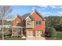 Two-story brick home with dormer windows, a two-car garage, and manicured front lawn at 4915 Bergen Ct, Cumming, GA 30040