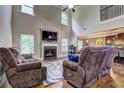 Open-concept living room with high ceilings, a fireplace, and an adjacent kitchen view at 5280 Clingman Ct, Douglasville, GA 30135