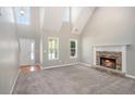 Bright living room with fireplace, carpet, and large windows that flood the space with natural light at 432 Tanner Farm Dr, Rockmart, GA 30153