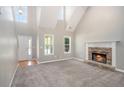 Bright living room with vaulted ceilings, a stone fireplace, plush carpeting, and abundant natural light at 432 Tanner Farm Dr, Rockmart, GA 30153