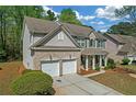 Side view of a brick front home featuring a two-car garage and lush landscaping at 3447 Dogwood Pass, Lithonia, GA 30038