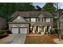 Charming two-story home features a two-car garage, brick facade, and beautifully landscaped front yard at 3447 Dogwood Pass, Lithonia, GA 30038