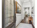 Elegant foyer with hardwood floors, decorative glass door, white walls and an artful painting at 1227 Magnolia Path Way, Sugar Hill, GA 30518