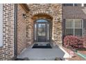 Inviting front entrance with stone archway, brick accents, and covered porch at 4241 Woodward Walk Ln, Suwanee, GA 30024