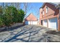A long driveway leads to a brick home with a three-car garage and lush green landscaping at 6450 Oak Valley Dr, Cumming, GA 30040