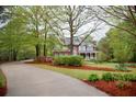 Charming two-story home featuring manicured lawn, mature trees, and a winding driveway at 8030 Eagle Lake Vw, Cumming, GA 30028
