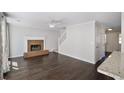 Bright living room with dark wood floors, white trim and a cozy brick fireplace at 12495 Concord Hall Dr, Alpharetta, GA 30005