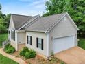 Home exterior with attached garage, complemented by well-maintained landscaping and natural surroundings at 5711 Parks Rd, Cumming, GA 30041