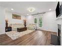 Bright living room featuring a fireplace, balcony access, and hardwood flooring at 3533 Settlement Rd, Tucker, GA 30084