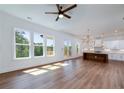 Open floor plan features hardwood floors, seamless transition from living area to kitchen, and abundant natural light through large windows at 4725 Young Deer Dr, Cumming, GA 30041