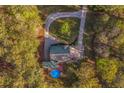 Aerial view of a home nestled in a wooded area, featuring a pool and long driveway at 5070 Smithfield Rd, Bowdon, GA 30108