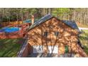 Back of house shows a large in-ground pool with wooden deck and two car garage at 5070 Smithfield Rd, Bowdon, GA 30108