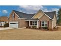 A welcoming brick home featuring a well-kept lawn, a two-car garage, and a cozy front porch at 1104 Aqua Shore Dr, Mcdonough, GA 30252