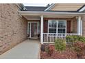 Inviting front porch with brick accents, decorative shrubbery, and a clear view into the home at 1104 Aqua Shore Dr, Mcdonough, GA 30252
