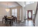 Elegant dining room featuring a crystal chandelier, hardwood floors, and wainscoting at 115 Westbury Ln, Johns Creek, GA 30005