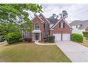 Charming two-story brick home with a manicured lawn and convenient two-car garage at 115 Westbury Ln, Johns Creek, GA 30005