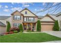 Charming two-story brick home with lush landscaping, a two-car garage, and inviting curb appeal at 2539 Larson Creek Cove, Duluth, GA 30097