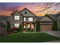 Charming two-story brick home with lush landscaping, a two-car garage, and inviting curb appeal at sunset at 2539 Larson Creek Cove, Duluth, GA 30097