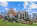 Beautiful brick home with meticulously maintained front yard, mature landscaping, and an inviting curb appeal at 5945 Boulder Bluff Dr, Cumming, GA 30040