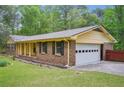 View of the home's brick exterior with a two-car garage, providing convenience and extra storage at 8540 Ridge Rd, Fairburn, GA 30213