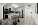A modern kitchen featuring stainless steel appliances, a kitchen island, and a black hexagon tile backsplash at 2965 Pharr Court South Nw # 304, Atlanta, GA 30305