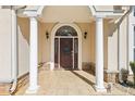 Welcoming front porch with elegant columns, stonework accents, and a beautiful arched front door at 3070 Glad Dale Se Dr, Conyers, GA 30094
