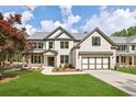 New construction home boasts a brick exterior, well-manicured lawn, and an attached two-car garage at 5816 Creek Indian Dr, Sugar Hill, GA 30518