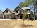 Attractive two-story home with a brick exterior, a two-car garage, gabled roof, and an inviting front entrance at 5816 Creek Indian Dr, Sugar Hill, GA 30518