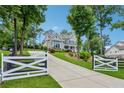 Long driveway leading to a charming two-story home with manicured lawn and gated entrance at 110 White Oak Trl, Cumming, GA 30028
